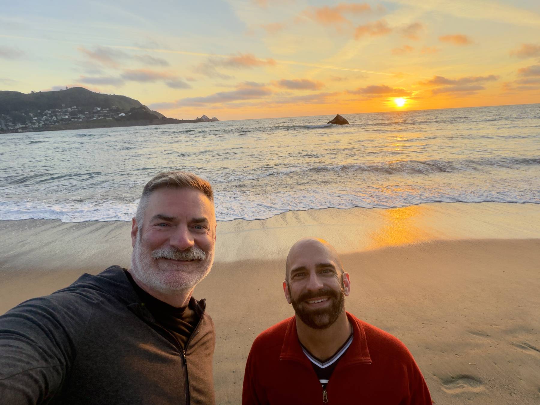 Jeremy and Alan smiling on the beach at Pacifica at sunset